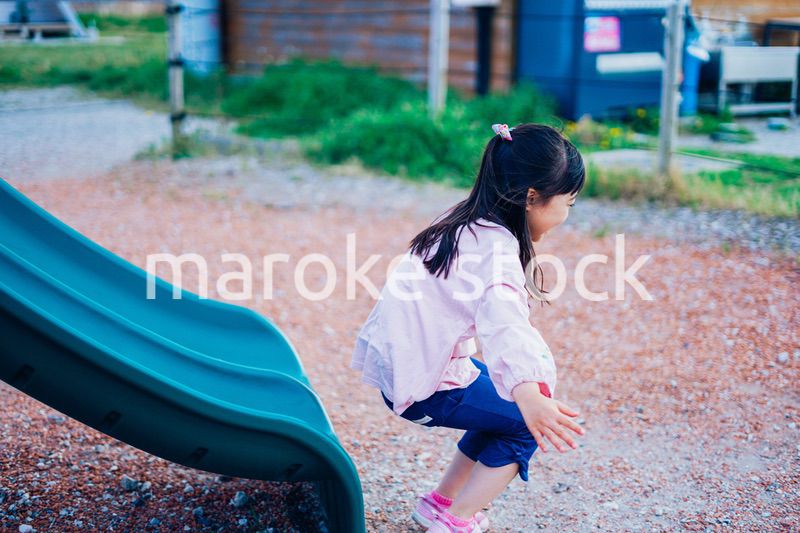 滑り台で遊ぶ小さな女の子
