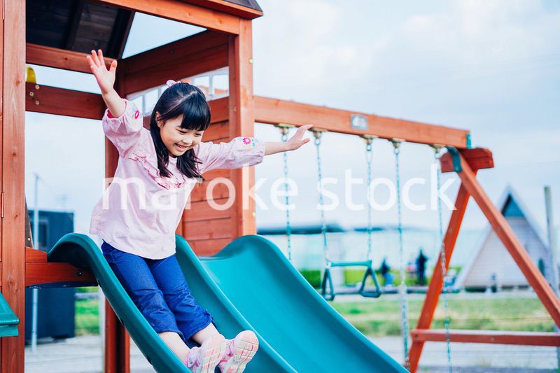 滑り台で遊ぶ小さな女の子