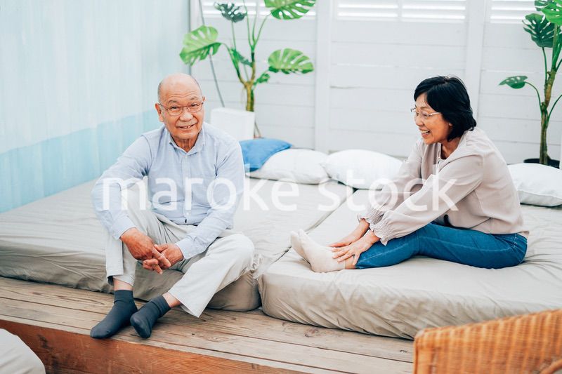 ベッドルームでくつろぐ高齢の夫婦