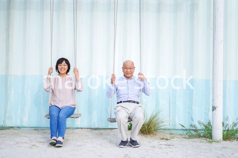 夫婦でブランコに乗るシニア