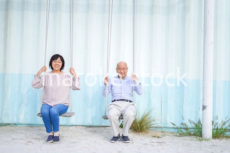 夫婦でブランコに乗るシニア