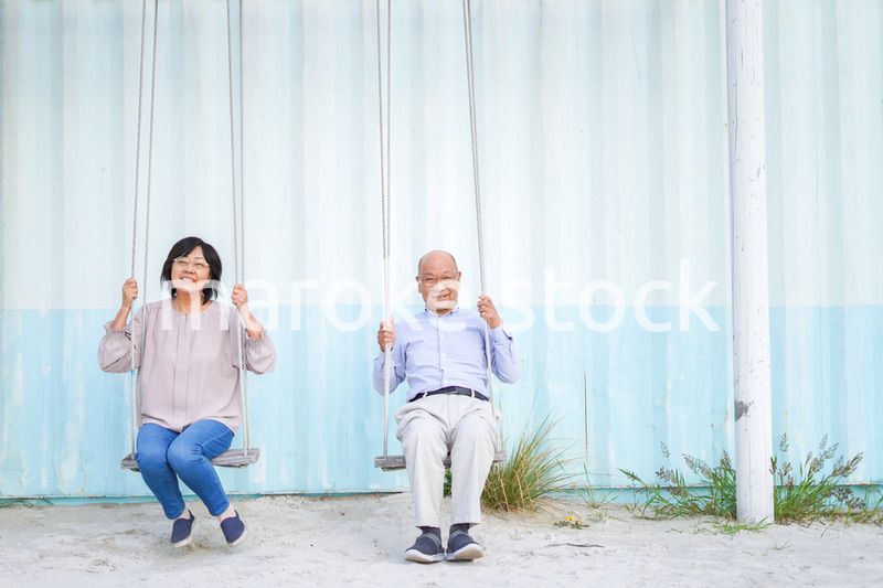 夫婦でブランコに乗るシニア
