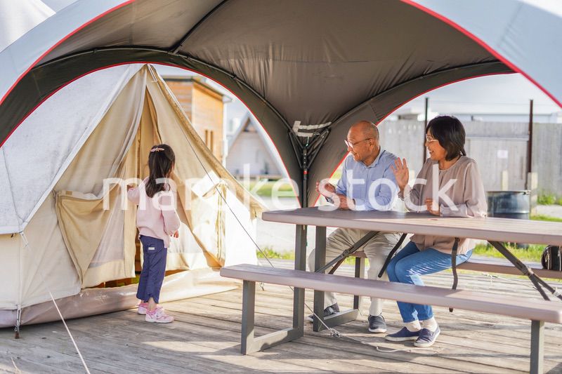 孫とキャンプをする高齢の夫婦