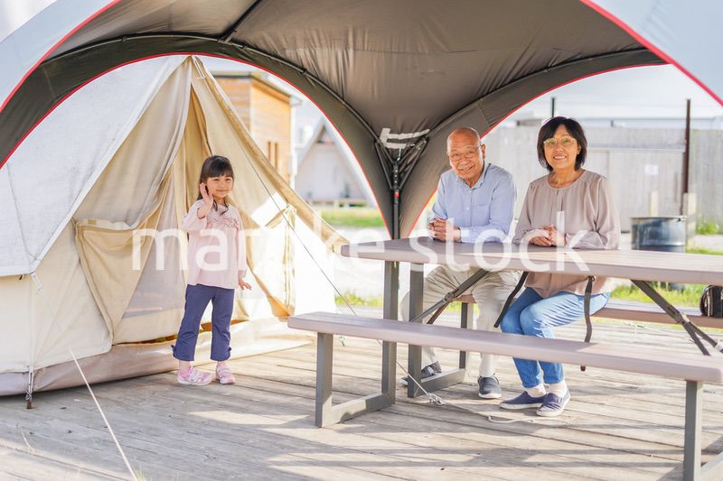 孫とキャンプをする高齢の夫婦