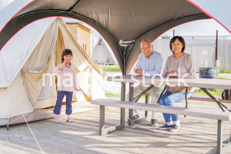 孫とキャンプをする高齢の夫婦