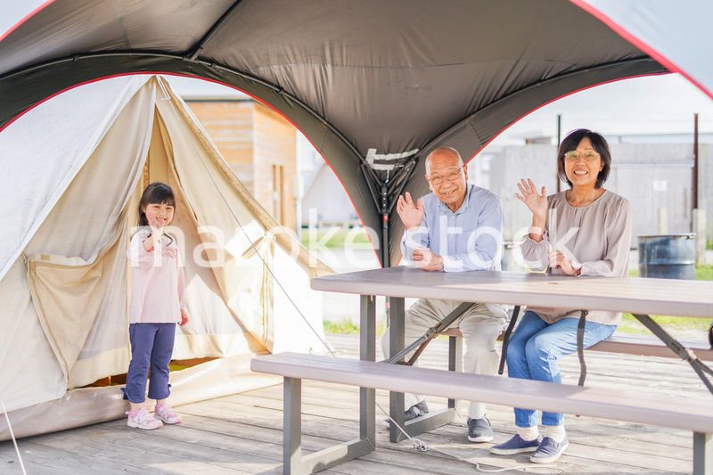 孫とキャンプをする高齢の夫婦