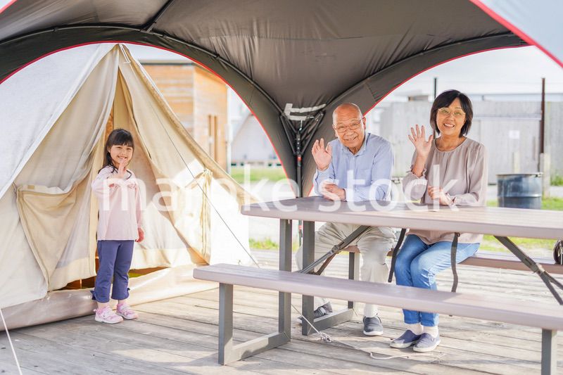 孫とキャンプをする高齢の夫婦