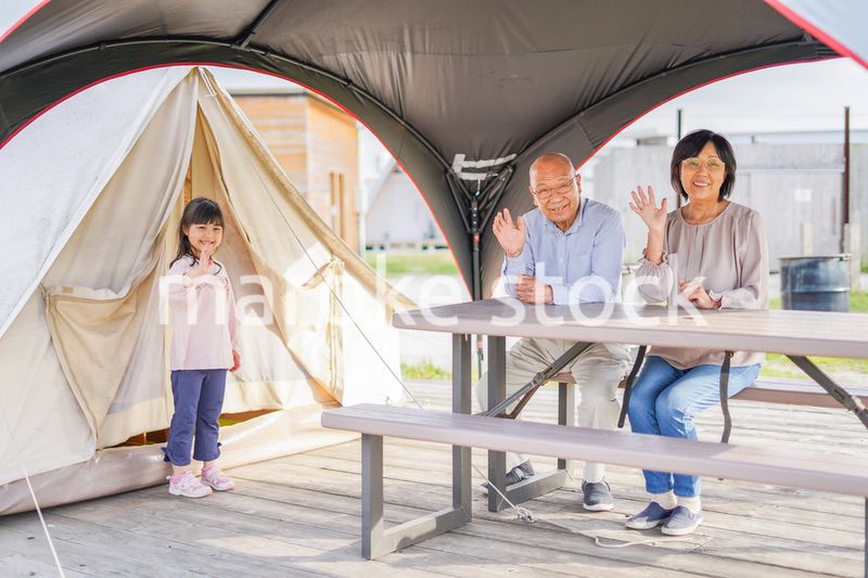 孫とキャンプをする高齢の夫婦