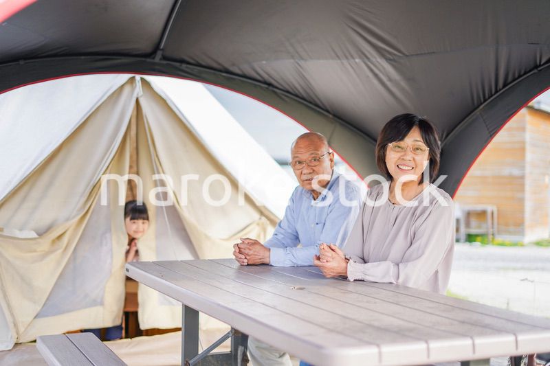 孫とキャンプをする高齢の夫婦