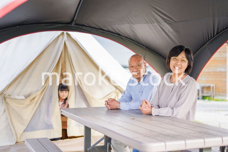 孫とキャンプをする高齢の夫婦