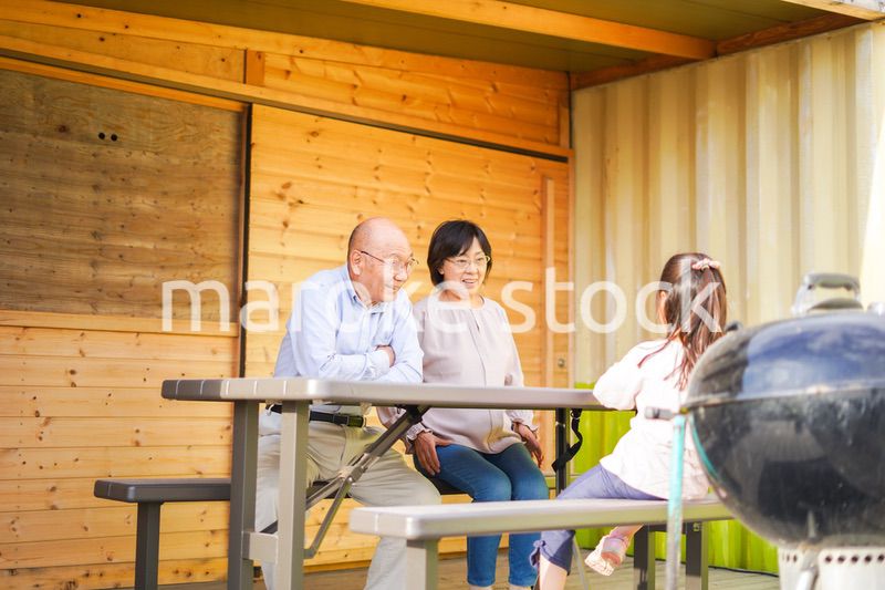 孫とキャンプをする高齢の夫婦