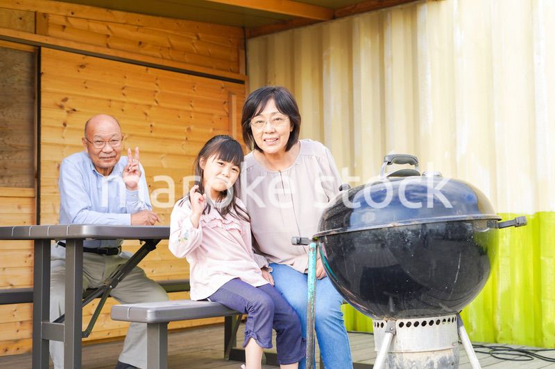 孫とキャンプをする高齢の夫婦