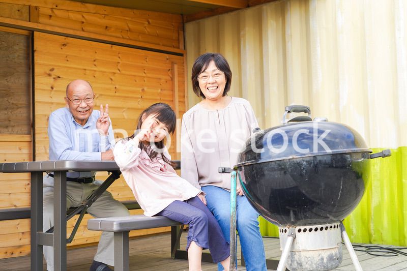 孫とキャンプをする高齢の夫婦