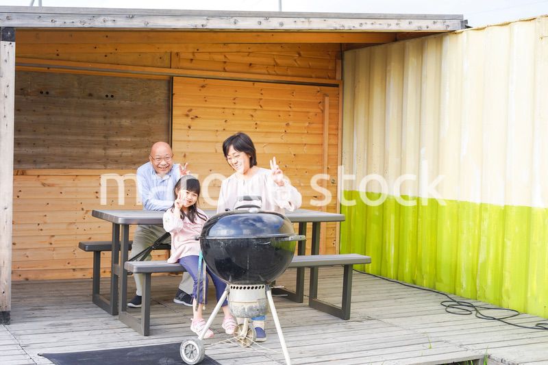 孫とキャンプをする高齢の夫婦