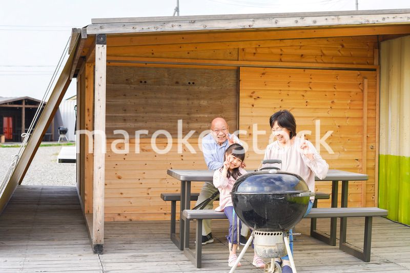 孫とキャンプをする高齢の夫婦