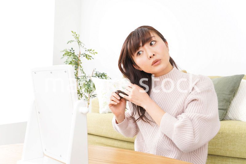 髪の毛のケアをする若い女性