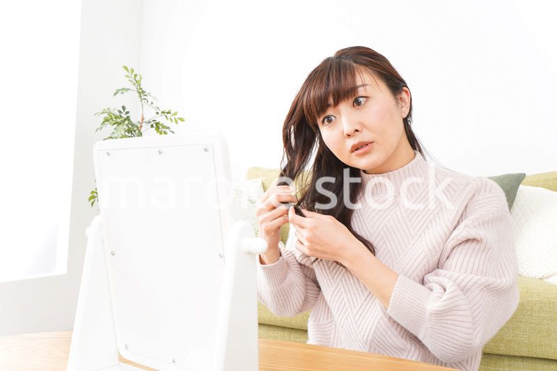 髪の毛のケアをする若い女性