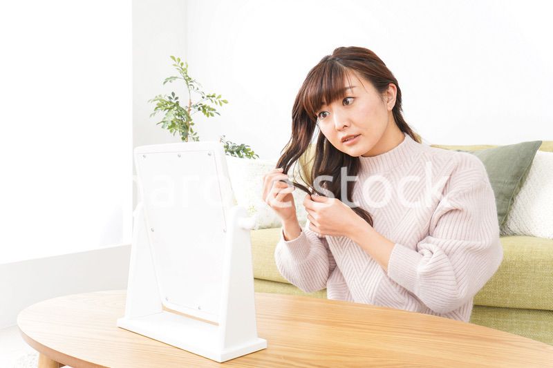 髪の毛のケアをする若い女性