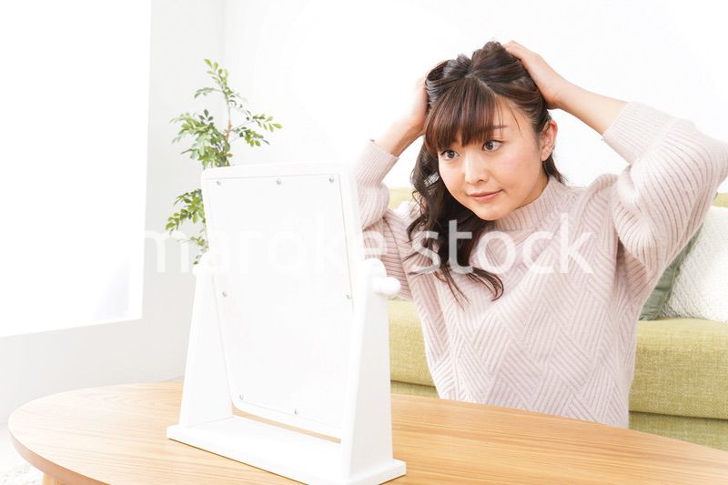 髪の毛のケアをする若い女性