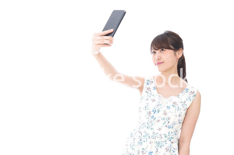 自撮り・ライブ配信をする若い女性