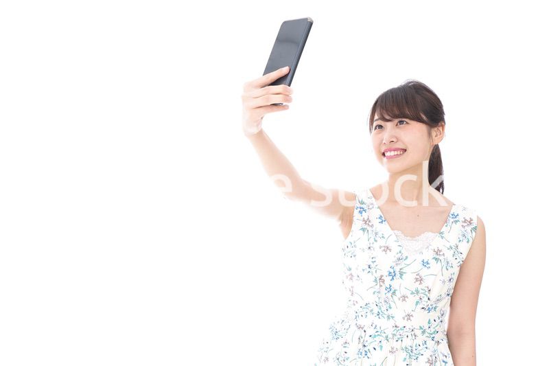 自撮り・ライブ配信をする若い女性