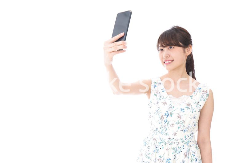 自撮り・ライブ配信をする若い女性