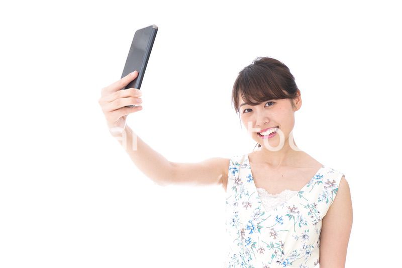 自撮り・ライブ配信をする若い女性