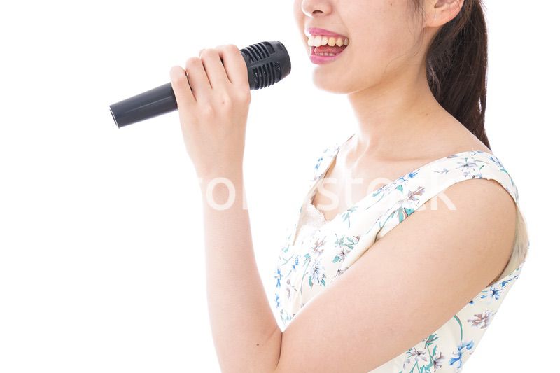 カラオケで歌を歌う若い女性