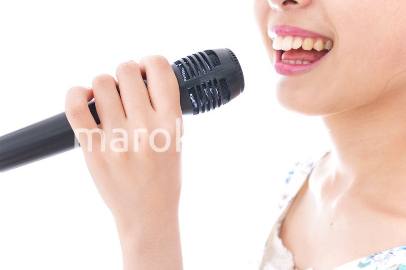 カラオケで歌を歌う若い女性