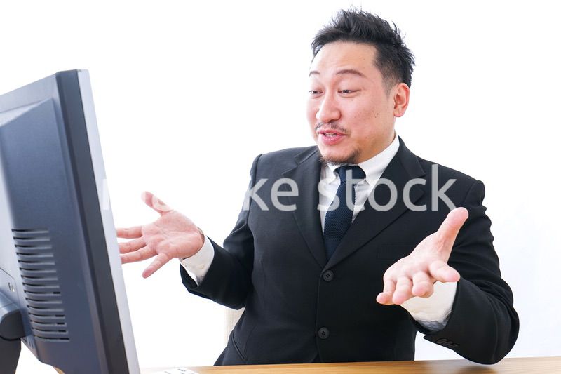 パソコンを見て驚くビジネスマン
