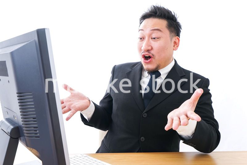 パソコンの前で憤慨するビジネスマン