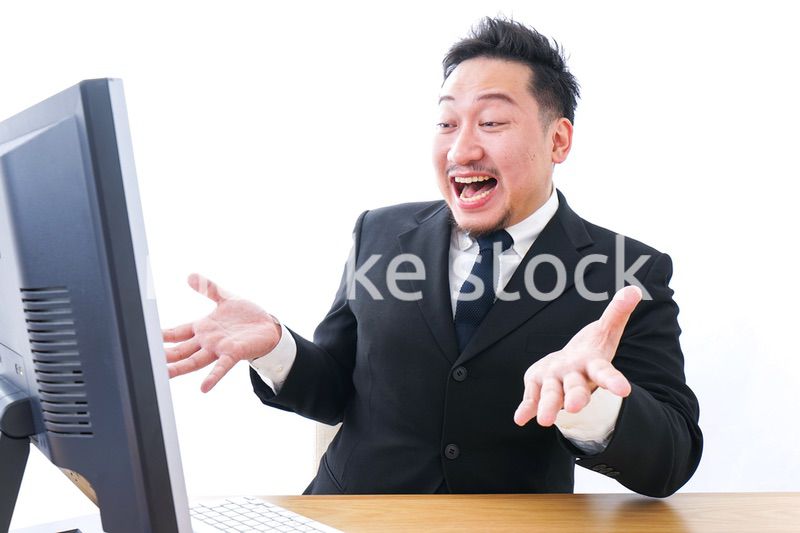 パソコンを見て驚くビジネスマン