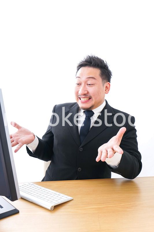 パソコンの前で憤慨するビジネスマン