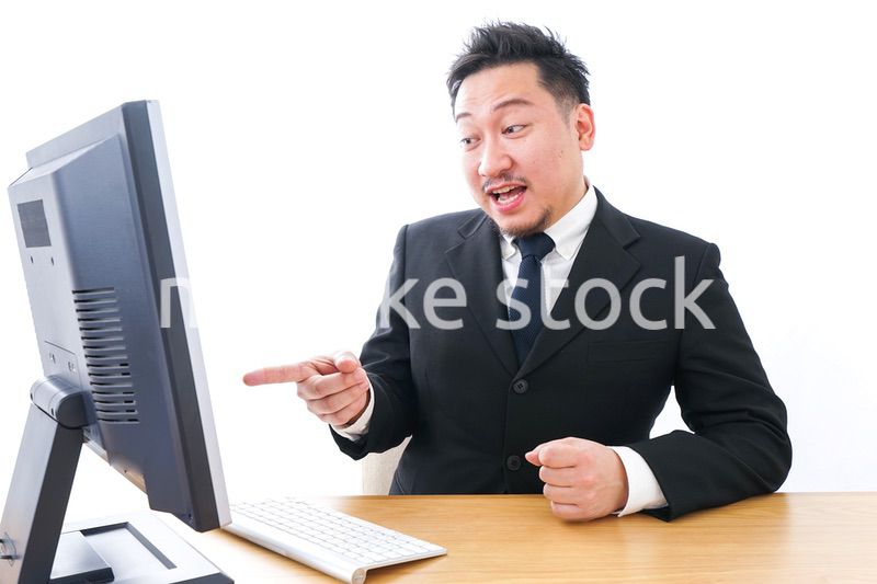 パソコンの前で憤慨するビジネスマン