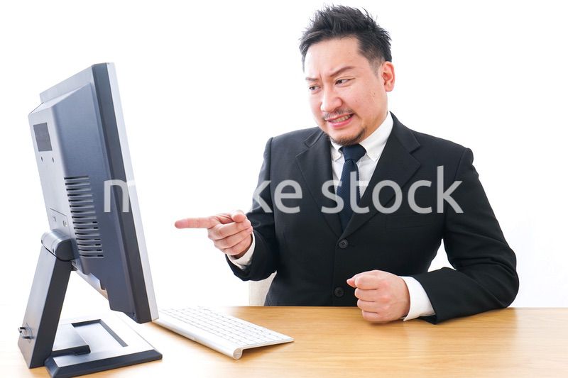 パソコンの前で憤慨するビジネスマン