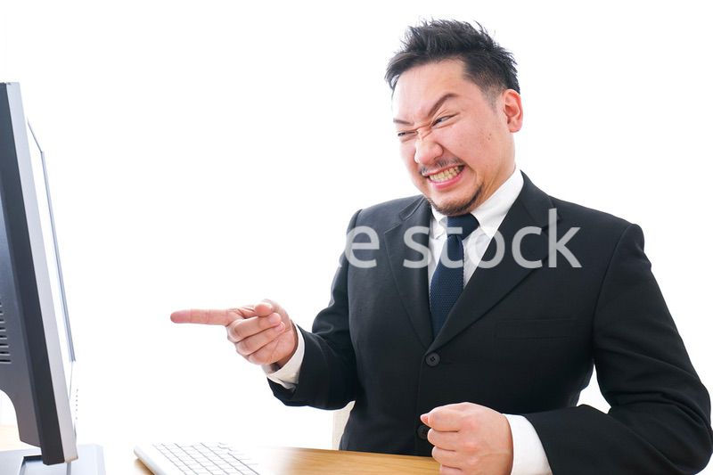 パソコンの前で憤慨するビジネスマン