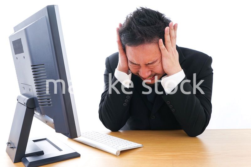 パソコンの前で憤慨するビジネスマン