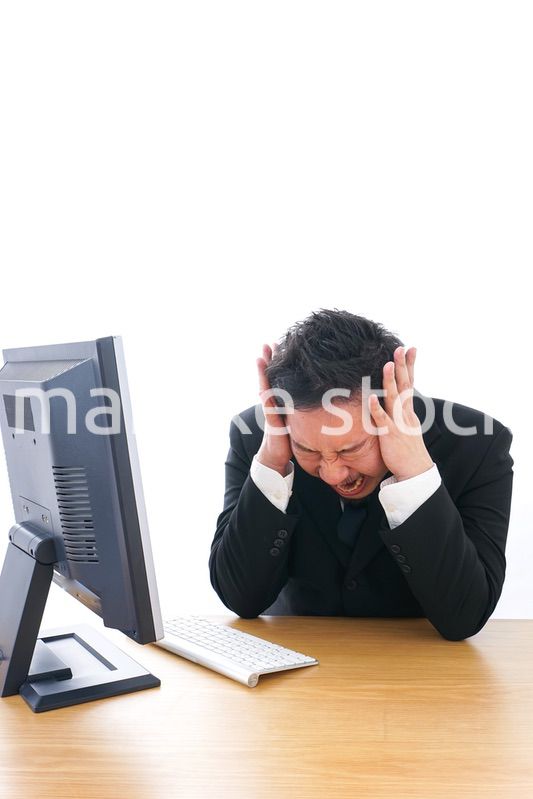 パソコンの前で憤慨するビジネスマン