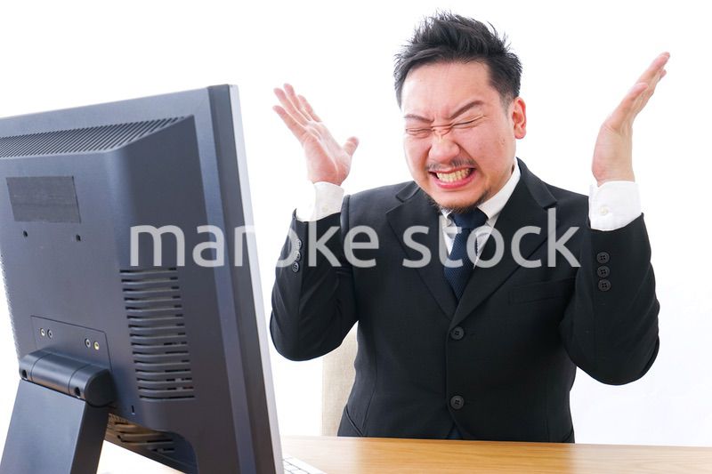 パソコンの前で憤慨するビジネスマン