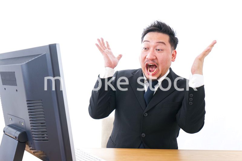 パソコンの前で憤慨するビジネスマン