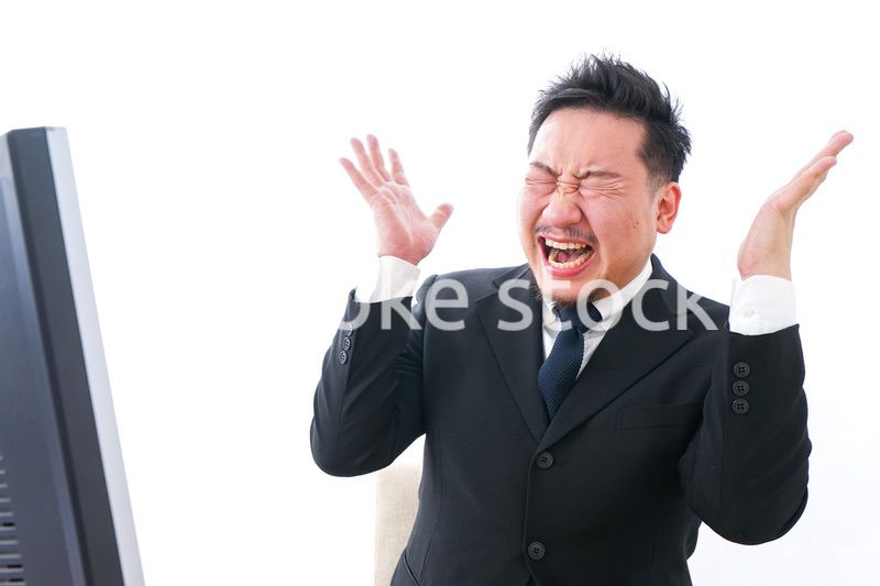 パソコンの前で憤慨するビジネスマン