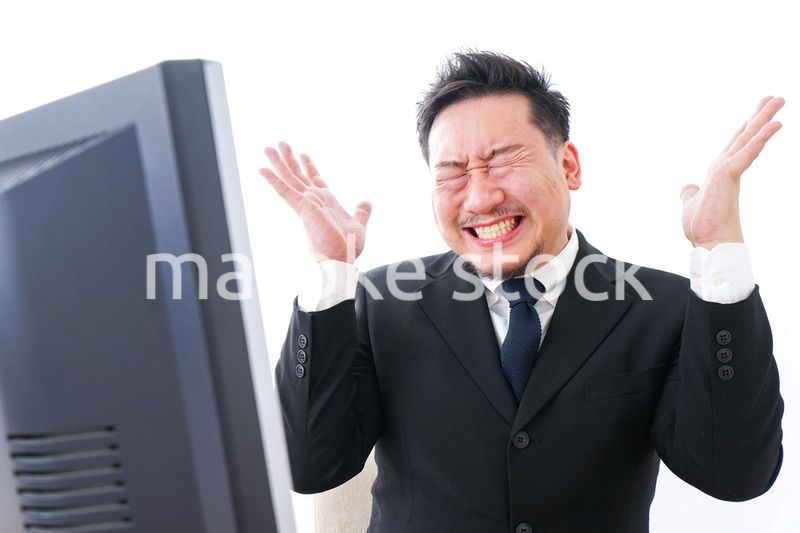 パソコンの前で憤慨するビジネスマン