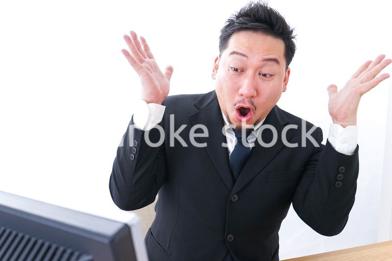 パソコンを見て驚くビジネスマン