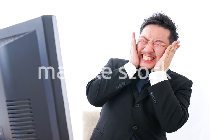パソコンの前で憤慨するビジネスマン