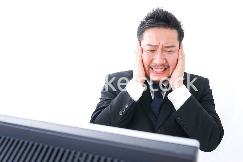 パソコンの前で憤慨するビジネスマン