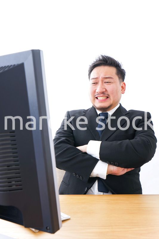 パソコンの前で憤慨するビジネスマン