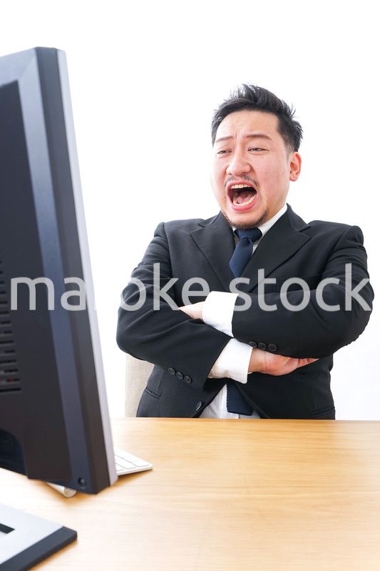 パソコンの前で憤慨するビジネスマン