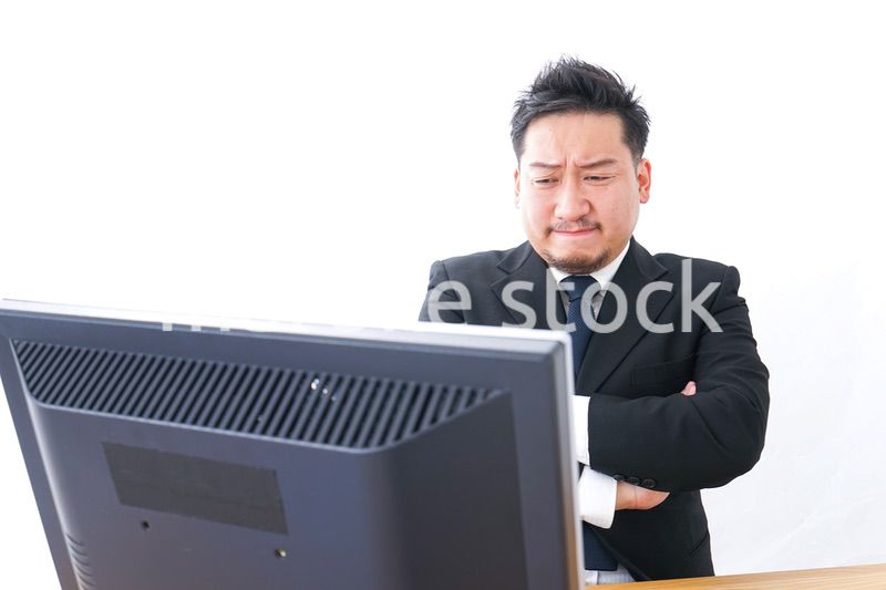 パソコンの前で憤慨するビジネスマン