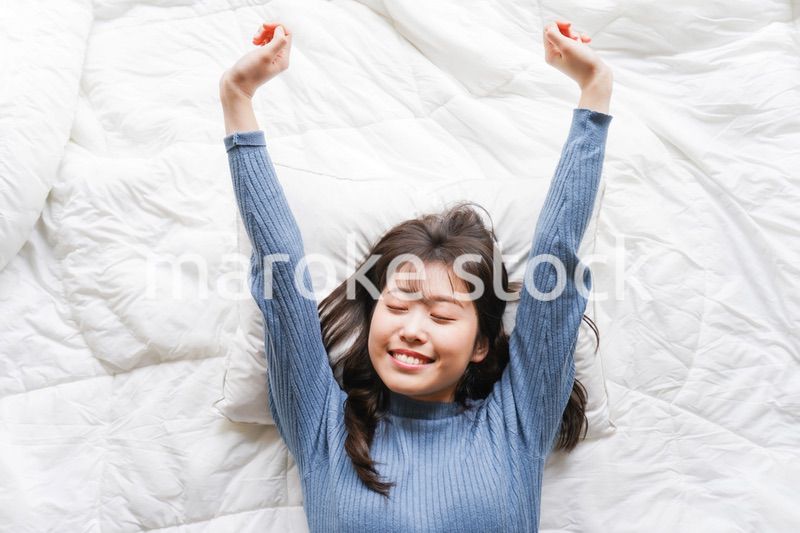 布団に入って睡眠を取る若い女性