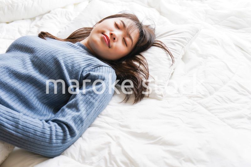 布団に入って睡眠を取る若い女性